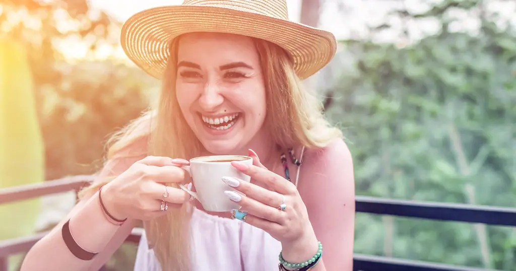 Premier rendez-vous: une femme rit, une tasse à la main