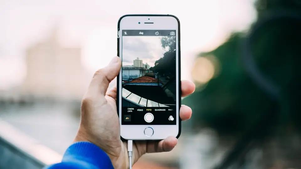 Créer son profil sur un site de rencontre: une main tient un smartphone prêt à prendre une photo de profil récente